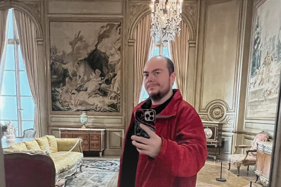 Man taking selfie in a mansion room with fancy furniture.